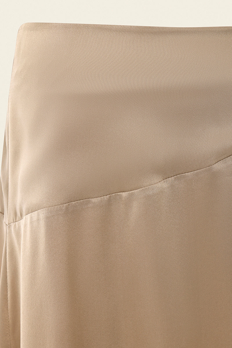 Nude IKINITA Nausica midi skirt displayed on a model, showcasing its elegant flowy fabric and stylish design.
