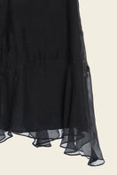 Black WAVE mini skirt by IKINITA, showing a close-up of the flowing, stylish skirt fabric and design details.