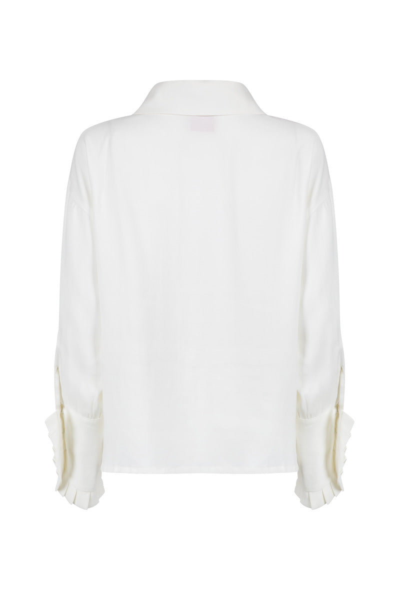 White Señorita Antonia blouse with long sleeves and button-up front, displayed on a hanger against a neutral background.