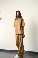 URAS FLO maxi skirt in sand color, flowing fabric with a relaxed fit, displayed on a hanger against a neutral background.