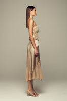 Nude IKINITA Nausica midi skirt shown in soft fabric, featuring a stylish, flowy design ideal for casual or dressy outfits.