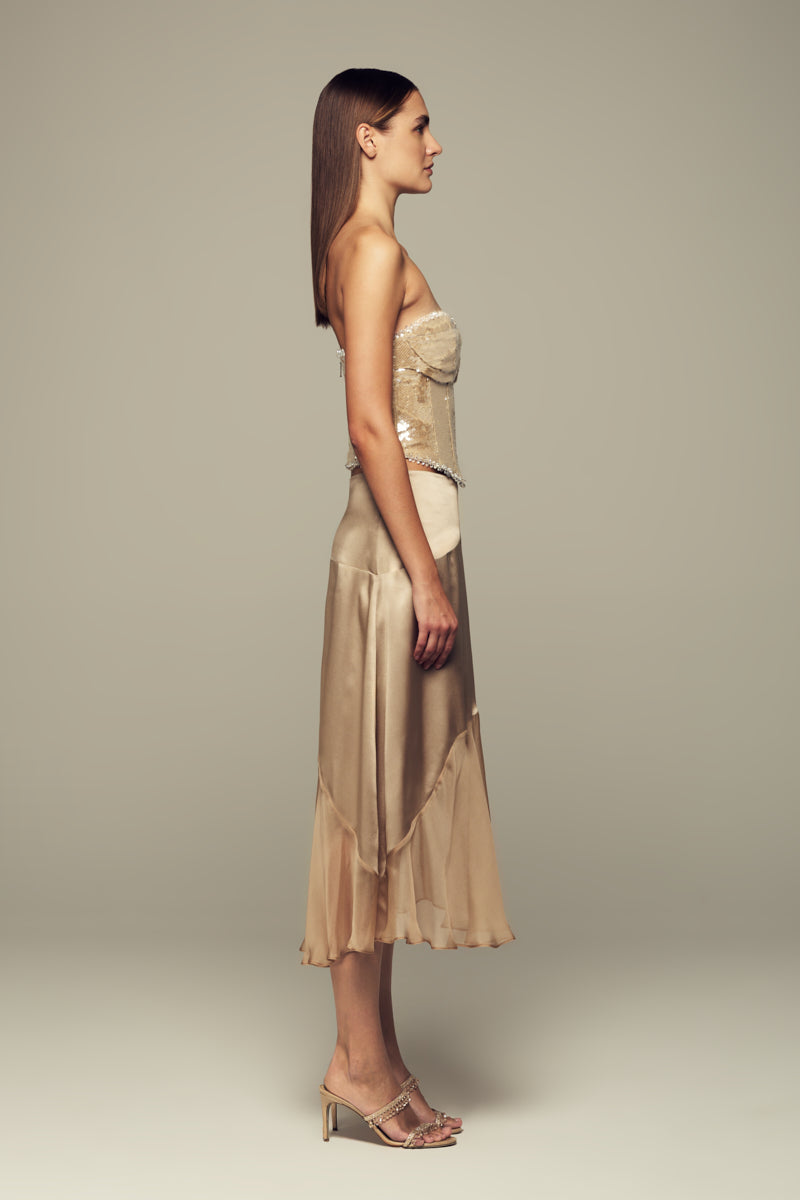 Nude IKINITA Nausica midi skirt shown in soft fabric, featuring a stylish, flowy design ideal for casual or dressy outfits.