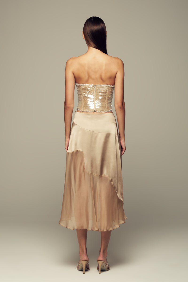 Nude IKINITA Nausica midi skirt featuring a sleek, flowing design and lightweight fabric, perfect for stylish daytime wear.