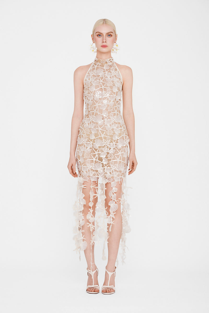 Valenciani Thalassa ivory halter maxi dress displayed on a hanger, featuring flowing fabric and elegant design.