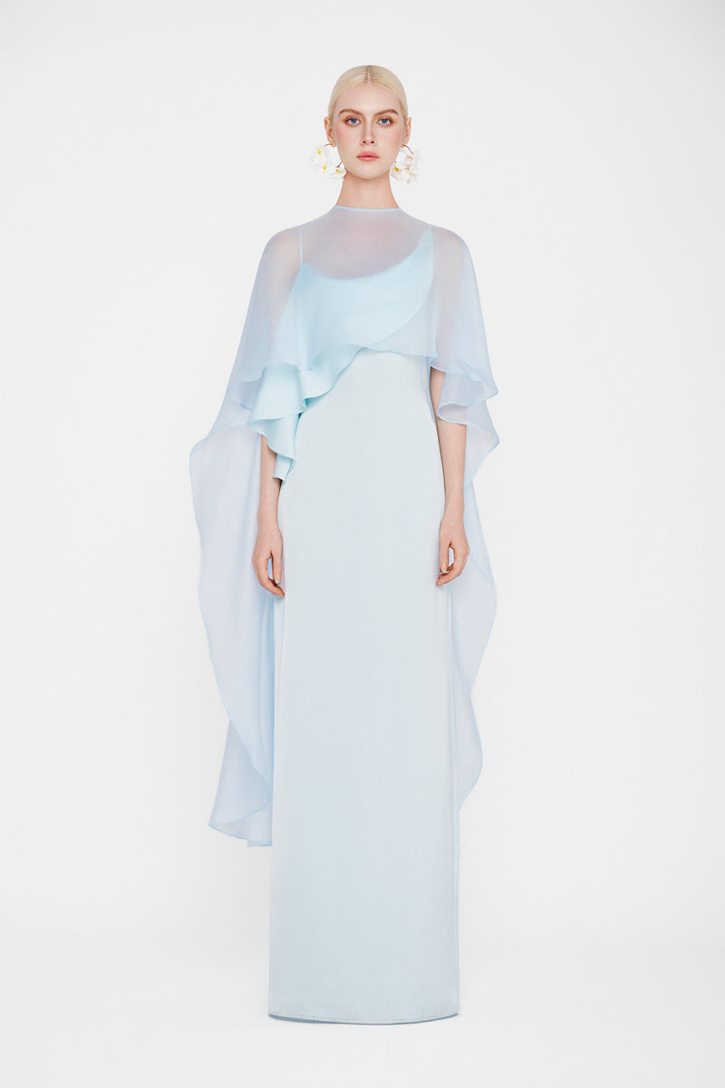 Valenciani Galatea Cape Gown in Ice Blue, elegant maxi dress with flowing fabric and cape detail, perfect for formal occasions.