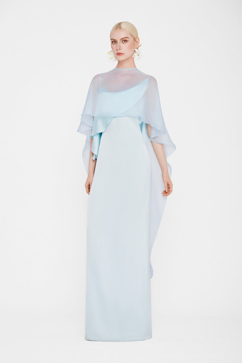 Valenciani Galatea cape gown in ice blue, elegant maxi dress with flowing fabric and stylish cape detail, perfect for formal occasions.