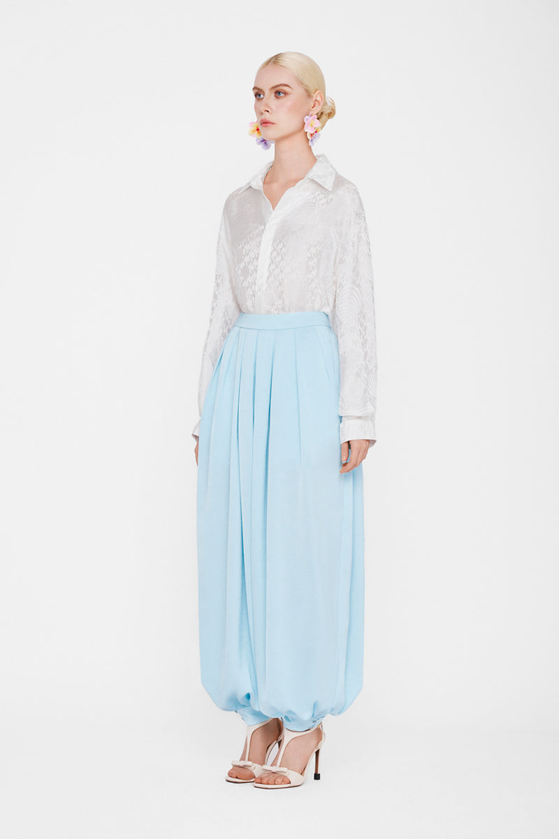 White silk shirt by Valenciani displayed on a mannequin, showcasing smooth fabric and classic collar style.