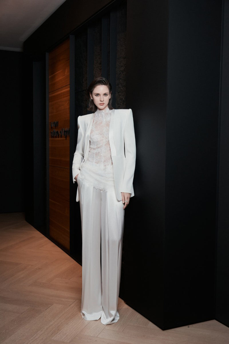 White LEKIEU CAEN pants displayed on a hanger with a tailored fit and clean design.