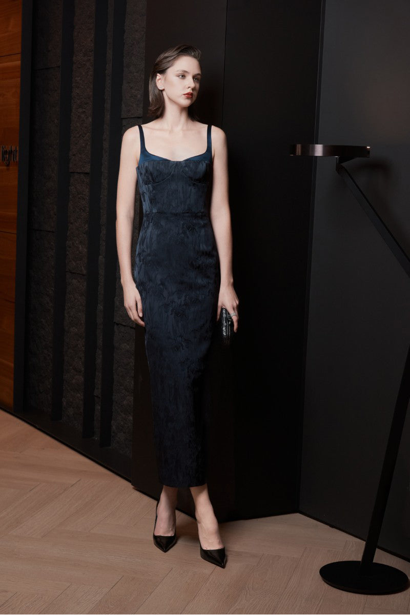 Midnight blue LEKIEU Palermo midi dress displayed on a hanger, showcasing its elegant design and flowing fabric.