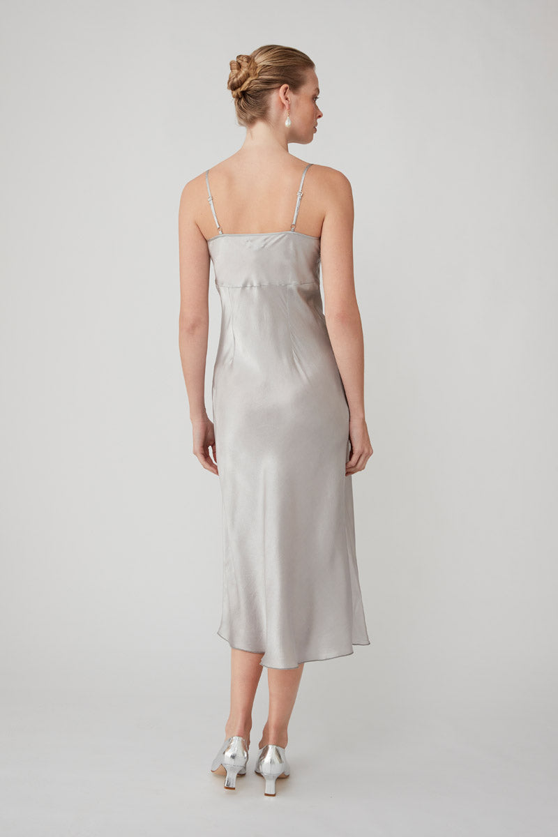 Silver MASTANI slip dress in midi length, featuring smooth fabric and elegant design, displayed on a hanger.