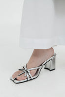 Silver Christin Wu Adrianna sandals featuring strappy design and low heel, perfect for summer and casual wear.