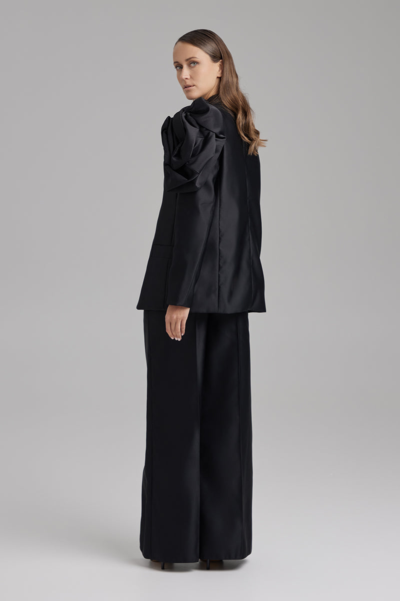 Black blazer from BAÉ Rose Jet collection, stylish tailored jacket with a sleek fit, shown on a model.