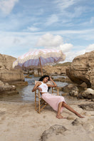 Pink midi skirt from IKINITA's Sunrise collection, featuring a flowing fabric and stylish design.