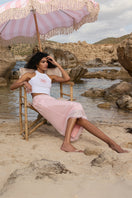 Pink midi skirt from IKINITA's Sunrise Skirt collection, featuring a flowy, stylish design ideal for casual or dressy occasions.