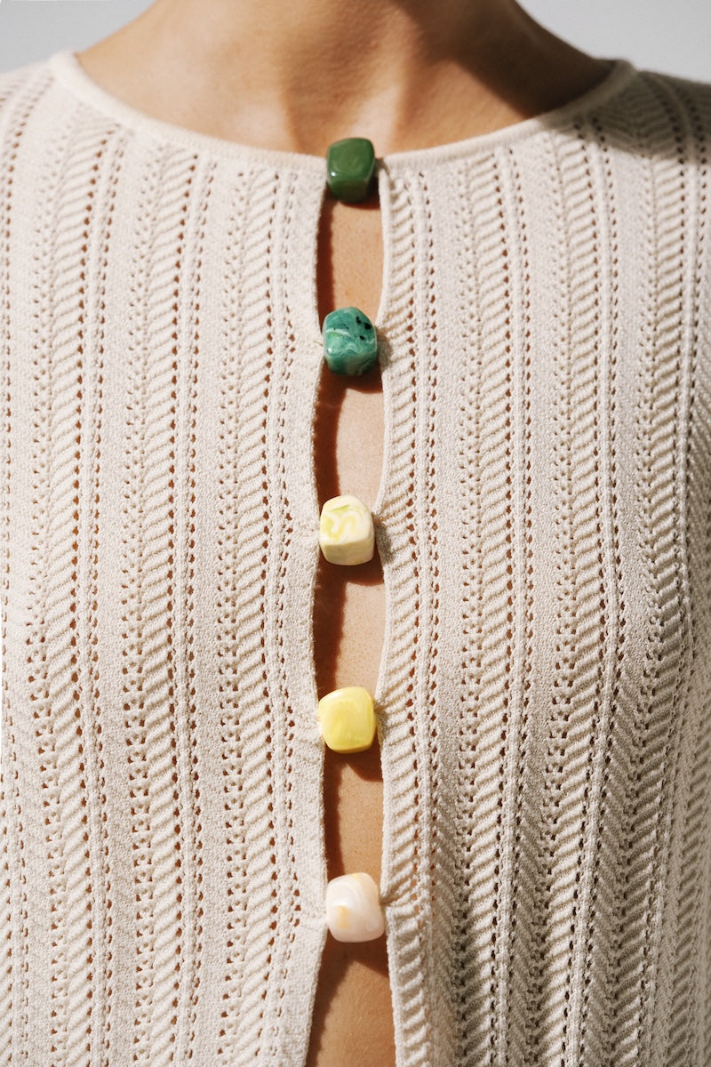 Ivory Baobab Corsica top shirt with a relaxed fit and soft fabric, displayed on a hanger.