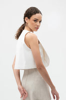 Ivory COVA crop top by ANA + MARIA, shown on a model, featuring a fitted design with stylish neckline and sleeveless style.