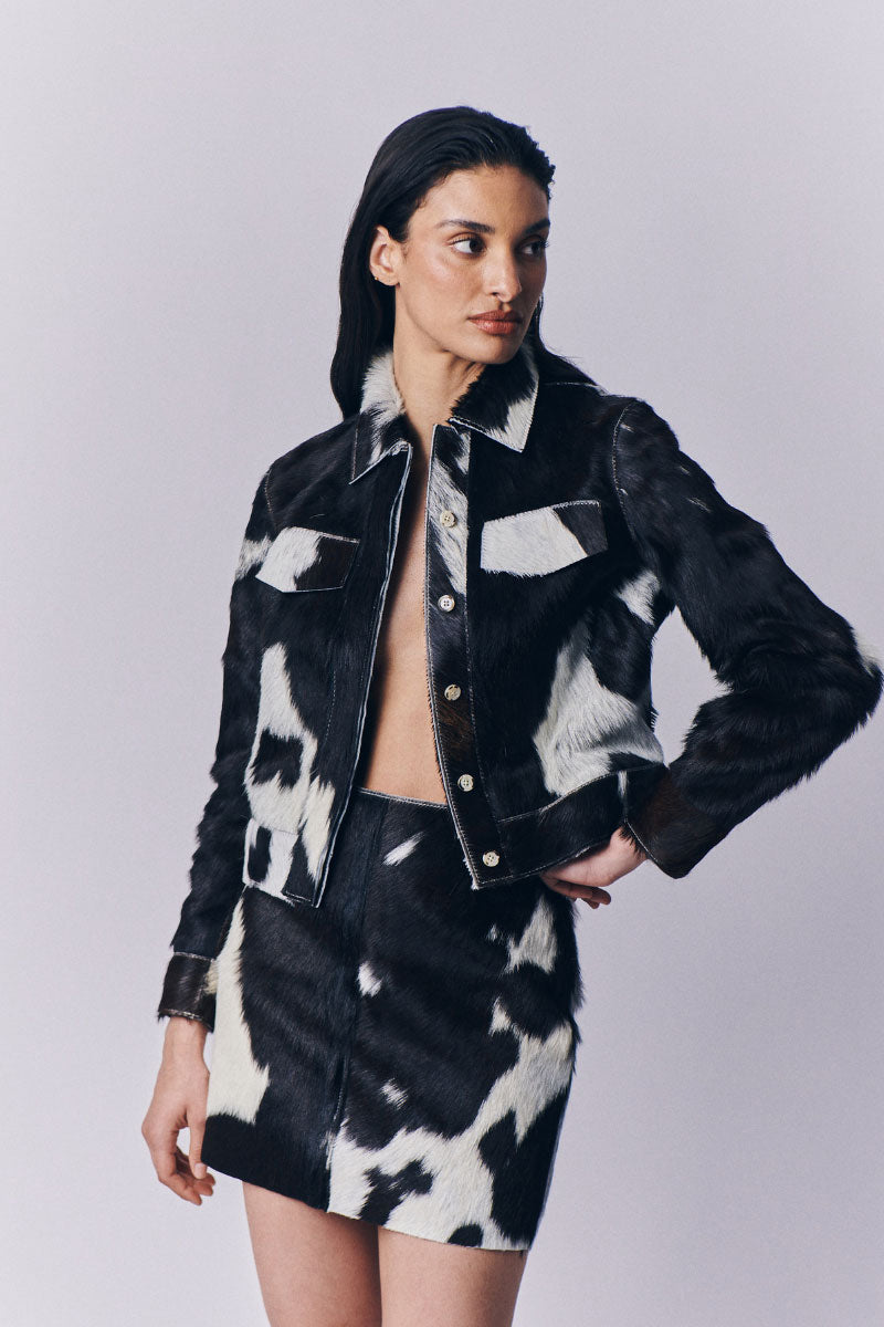 Black and white cowhide mini skirt by ZUT, showcasing a stylish, short skirt with a bold animal print pattern.