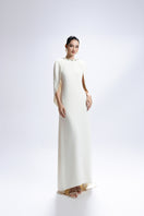 White Valenciani gown with a cowl back and cape sleeve, elegant design perfect for formal occasions.