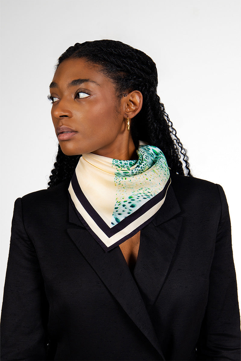 Creamy Moussard silk scarf by Amel Batita draped around neck, showcasing soft, luxurious blue fabric and elegant design.