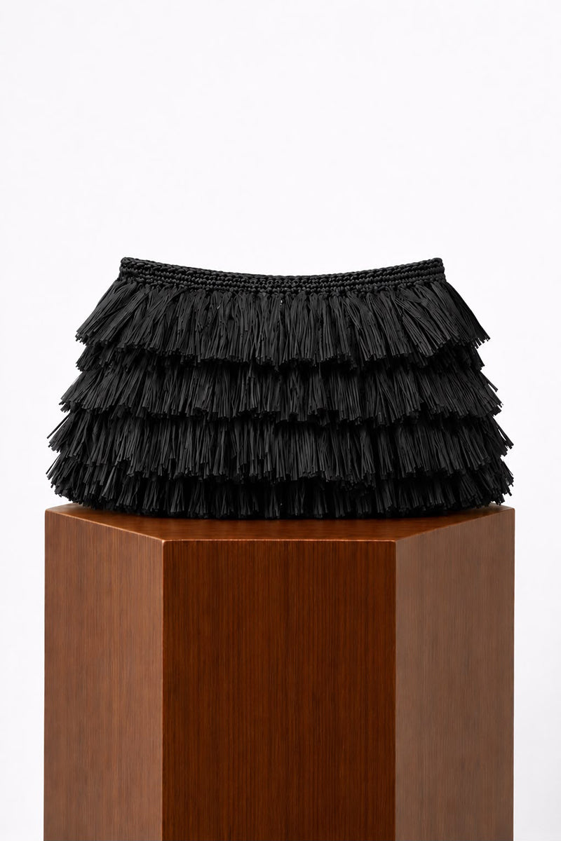 Black crochet raffia clutch bag by Folklore The Label with intricate crochet pattern and woven raffia texture.