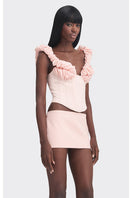 Pink croissant-shaped corset bustier from Stolen Stores, styled as a trendy pink tops fashion piece with detailed design.