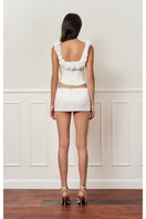 Off-white croissant corset bustier top by Stolen Stores, featuring structured design and stylish fit, shown on a model.