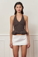 Mini dark brown croissant top with polka dot pattern from Stolen Stores, casual women's blouse shown on a hanger.