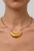 Gold croissant chain necklace from Oz Objects, featuring a detailed, curved pendant on a sleek gold chain.