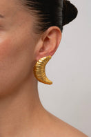 Gold croissant earrings by Oz Objects featuring detailed, shiny croissant-shaped design for stylish jewelry.