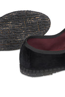 Black Flabelus Antonia flats with pointed toes and sleek design, shown on a model's feet.