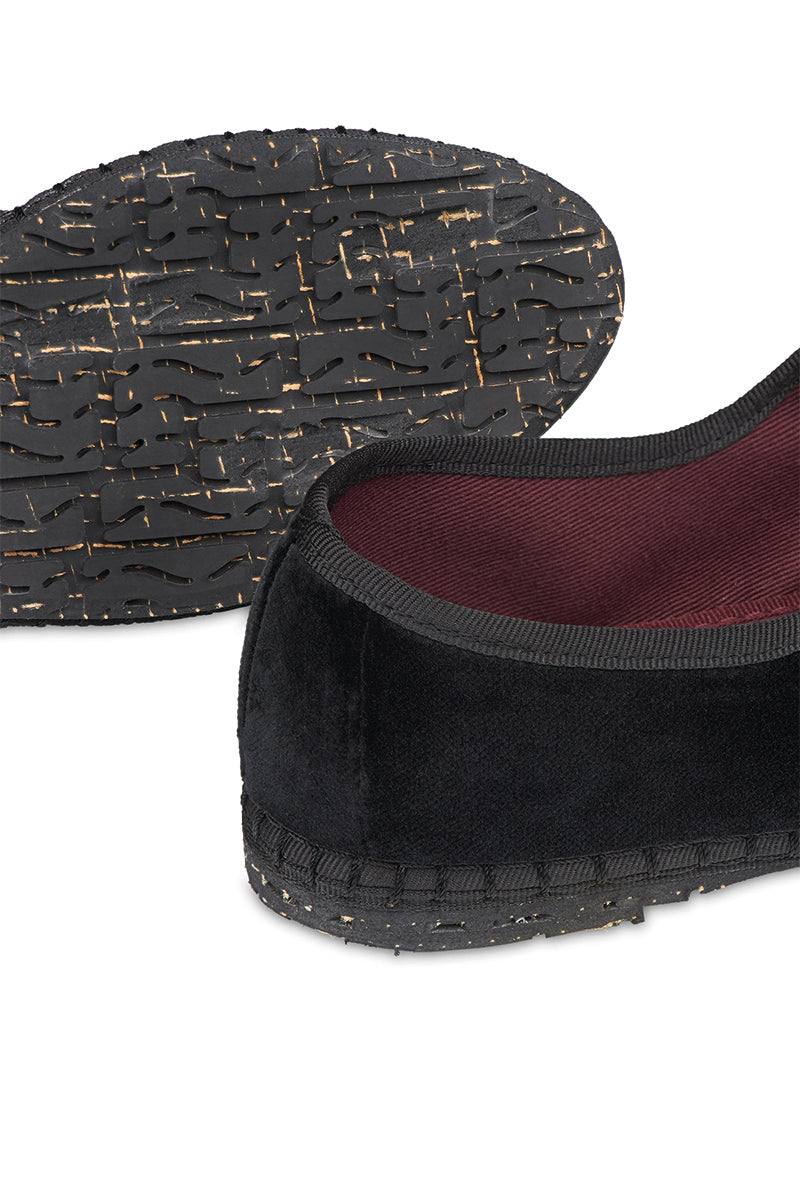 Black Flabelus Antonia flats with pointed toes and sleek design, shown on a model's feet.