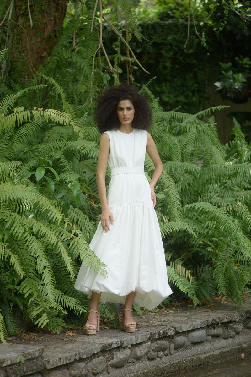 Ivory Cupula Dress by ANA + MARIA, a flowing maxi dress with elegant design, showcased in a campaign photo.