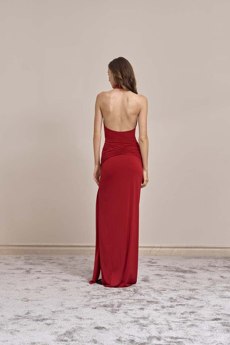 Red curve maxi gown by Yassmin Saleh, back view showcasing elegant drape and fitted silhouette.