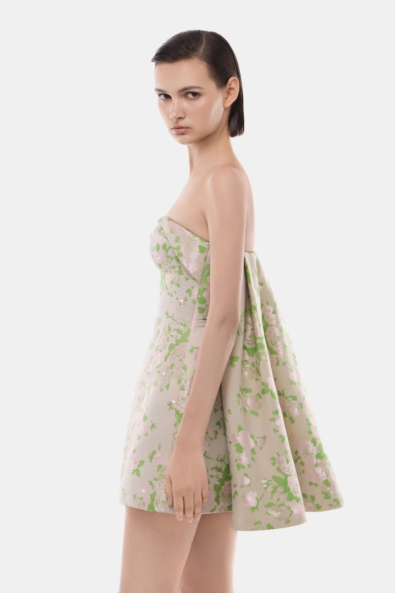 Light pink pastel corsetry mini dress by Montsand with a detachable cape, featuring fitted bodice and elegant design.
