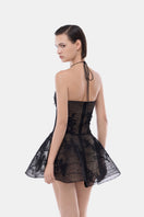 Black floral appliqué halter mini dress by Montsand featuring a fitted silhouette and elegant floral detailing.