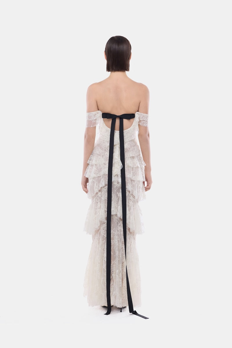 Ivory lace ruffle strap-off gown by Montsand featuring delicate lace details and flowing fabric.