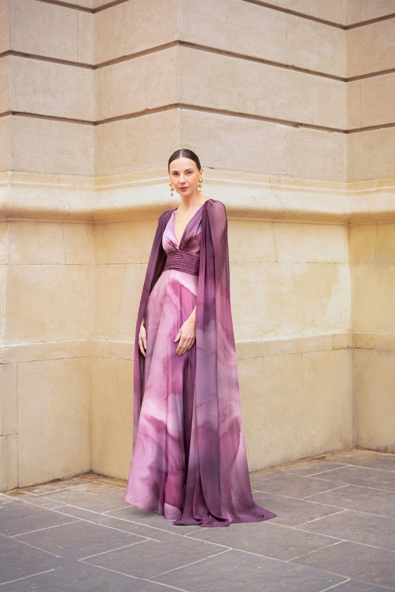 Purple print DALIA maxi dress by TINTA LATINA, flowing fabric with floral design, displayed on a hanger.