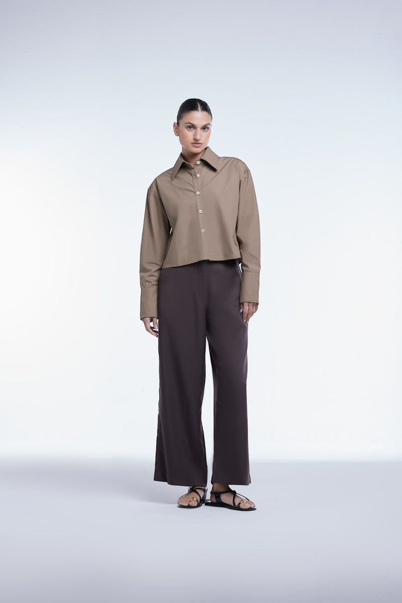 Cropped cotton button-down shirt by Dāl the Label, featuring a classic collar and relaxed fit, displayed on a hanger.
