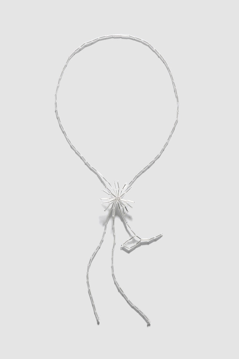 Silver dandelion tie bolo necklace by Pura Utz, featuring a detailed dandelion charm on a sleek cord.