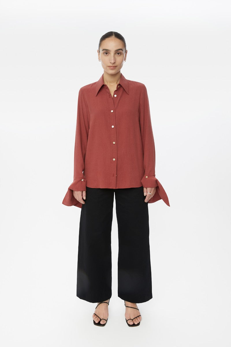 Relaxed long cuff top from Dāl the Label, stylish shirt with rolled cuffs and a comfortable fit, showcased in a fashion lookbook.