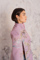 Nadya Shah Hydra Lilac Cape jacket displayed on a hanger, showcasing its elegant lilac fabric and stylish design.