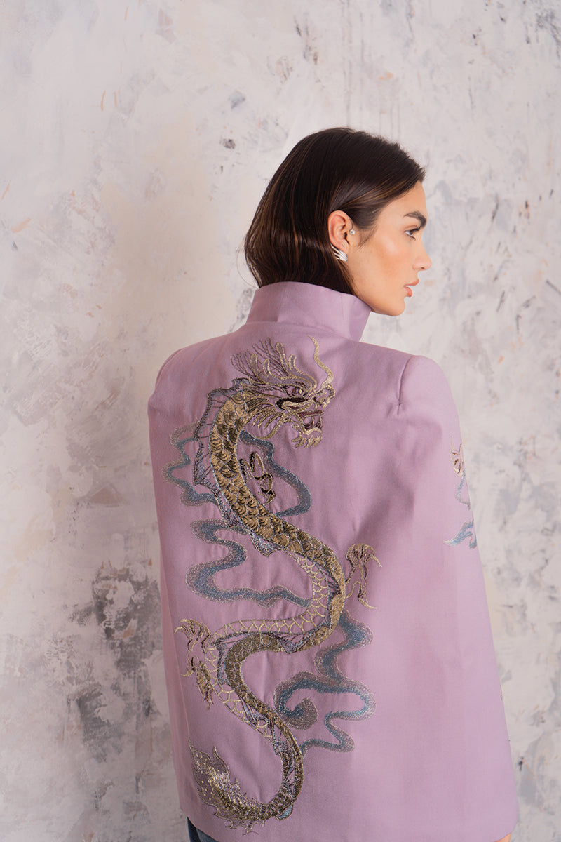 Nadya Shah Hydra Lilac Cape jacket draped over a hanger, showcasing its soft fabric and elegant lilac color.