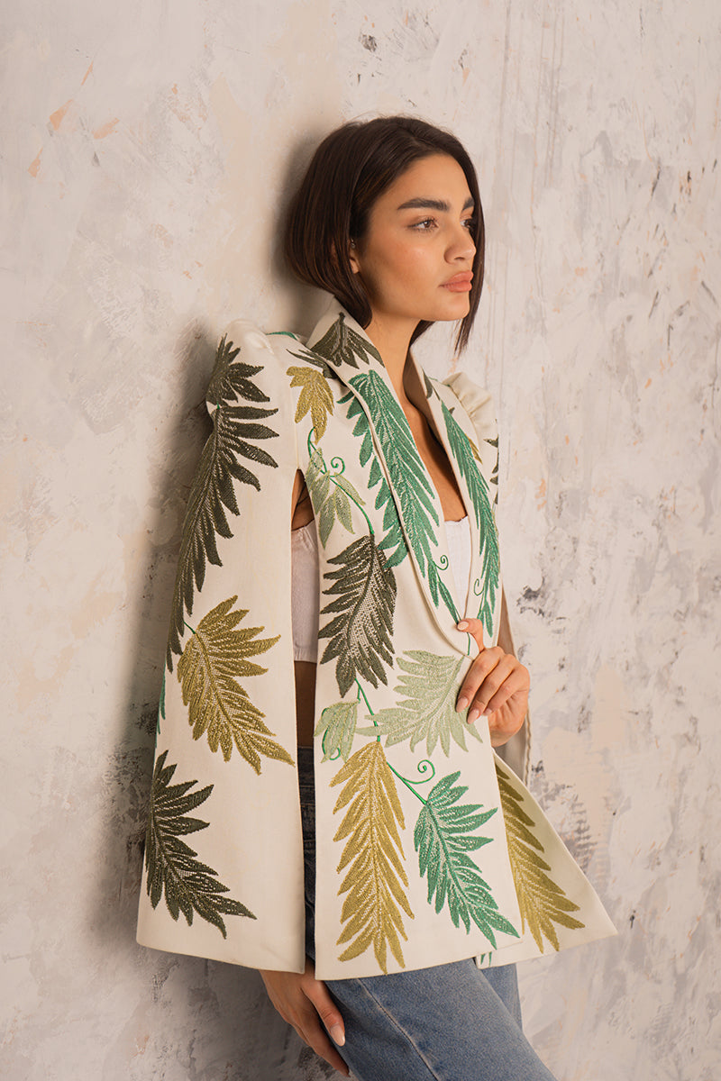 Nadya Shah Cara Leaf Cape jacket in lightweight fabric with a leafy pattern, displayed on a hanger against a neutral background.