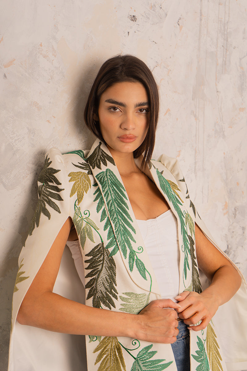 Nadya Shah Cara Leaf Cape jacket with leaf-patterned design in lightweight fabric, displayed on a hanger.