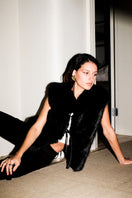 Black Verheyen Serena gilet jacket with a sleek design and zipper closure, displayed on a hanger.