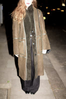Verheyen ZINA Biker Green Shearling Coat displayed on a hanger, featuring a vibrant green color and shearling details.