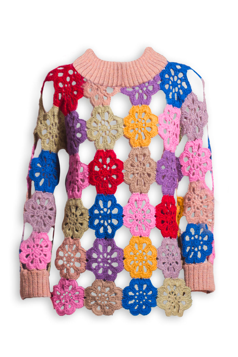 First Born Knits Edie crochet sweater displayed on a hanger, showcasing its textured crochet pattern and cozy fit.