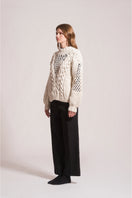 First Born Knits DAFNE knitted sweater featuring a cozy, textured design in neutral tones, perfect for casual wear.