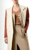 Gvasalia double-breasted coat with striped sleeves, tailored fit, and classic design, shown on a hanger.