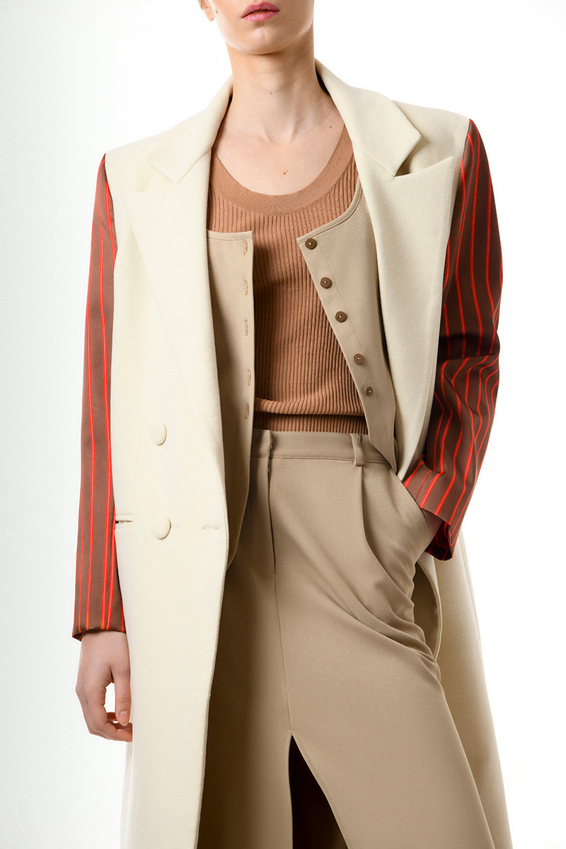 Gvasalia double-breasted coat with striped sleeves, tailored fit, and classic design, shown on a hanger.